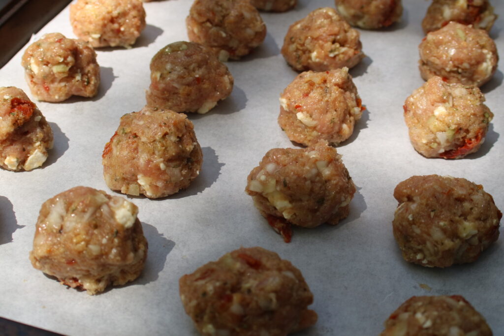 Step 2: Using a spoon scoop and shape into 28 meatballs, and place on parchment lined baking sheet